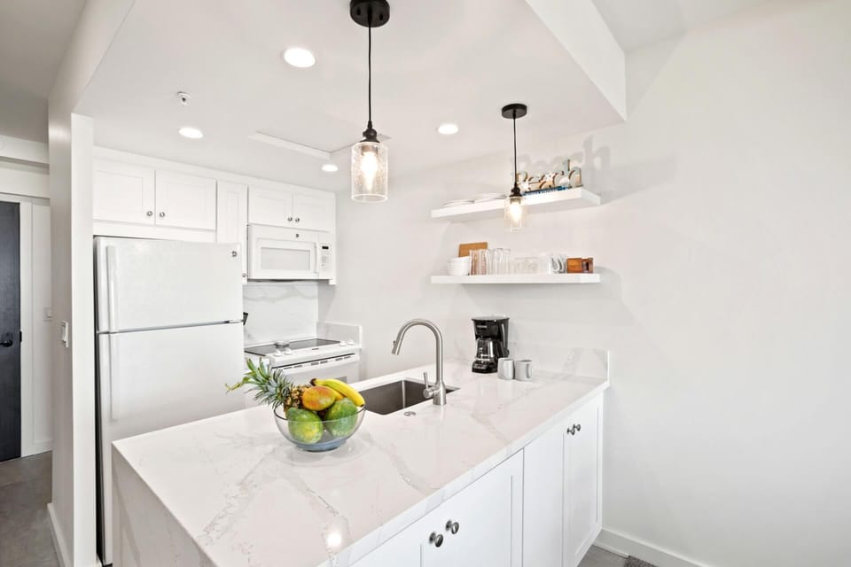     Bright, modern kitchen with sleek finishes, island seating, and tropical touches, perfect for relaxed vacation meals. WH1-1218