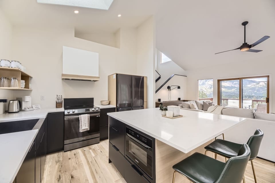 Your modern kitchen flows seamlessly into the living area, where mountain views frame every meal you prepare.