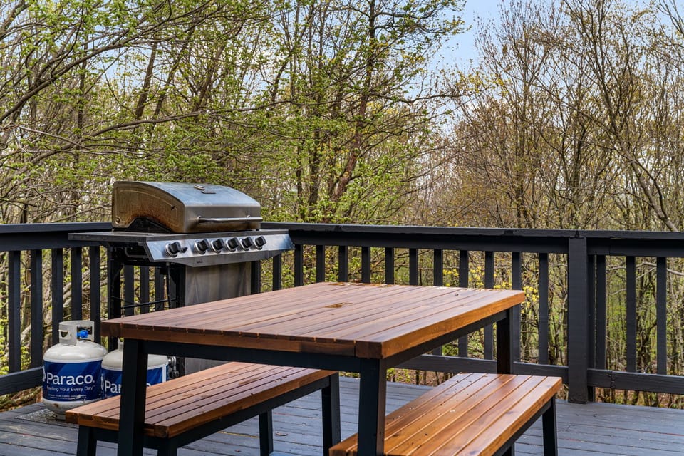 Dine outdoors with a BBQ grill and large picnic table.