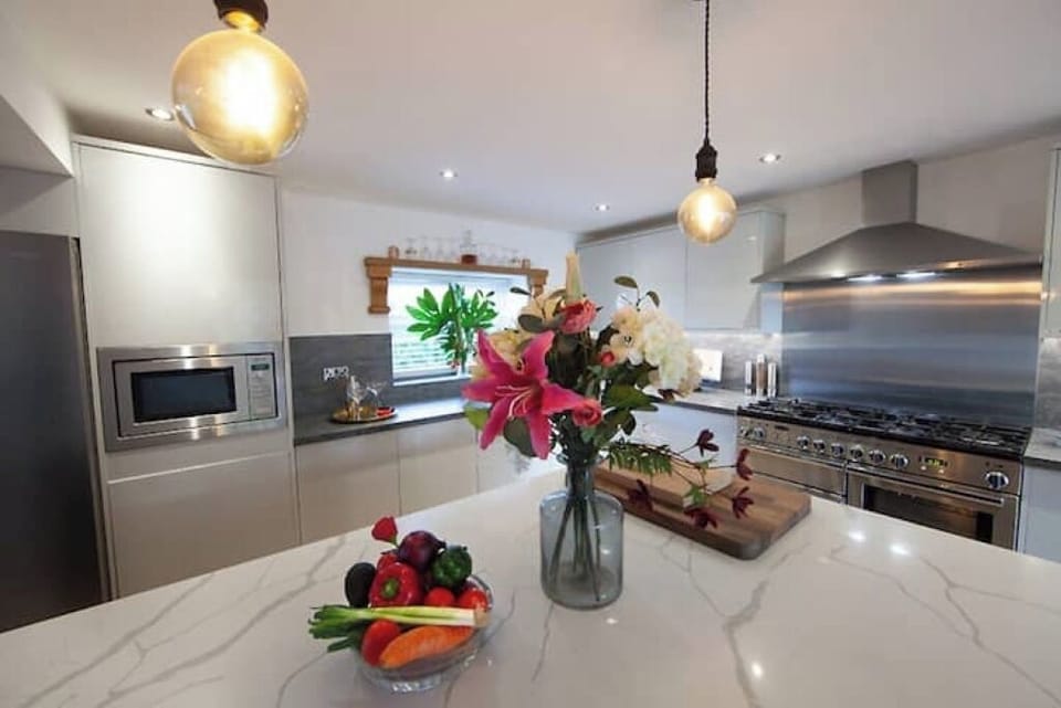 Spacious modern kitchen with centre island and professional range cooker.
