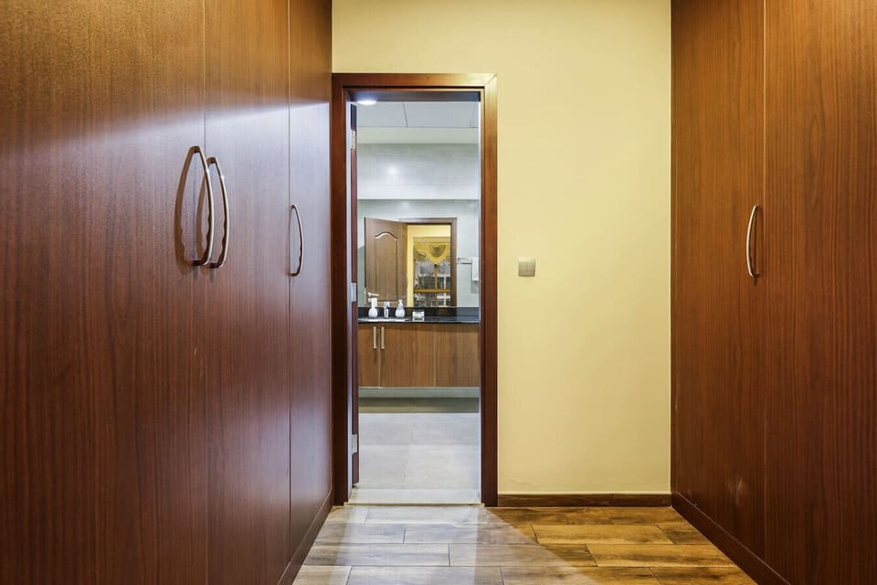 Hallway: Elegant wooden cabinetry leads you to a stylish retreat, ready for your Dubai adventure!