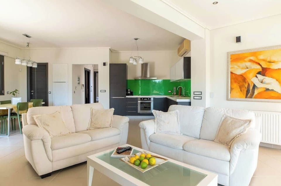 Modern open-plan living with comfy seating, full kitchen, and dining area.