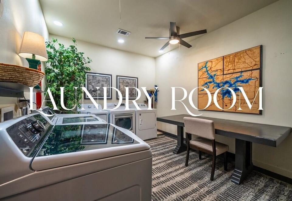 This spacious laundry room doubles as a utility nook, featuring folding space, a full desk area, and bright, inspiring décor.