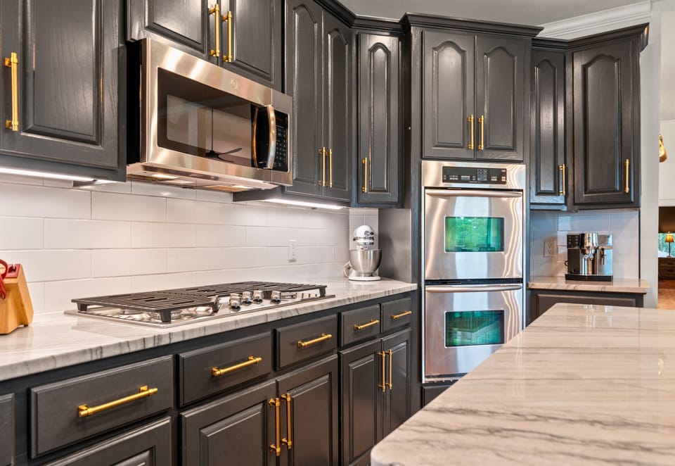 Double ovens, a six-burner gas cooktop, and marble counters make this space a dream for anyone who loves to cook or entertain in style.