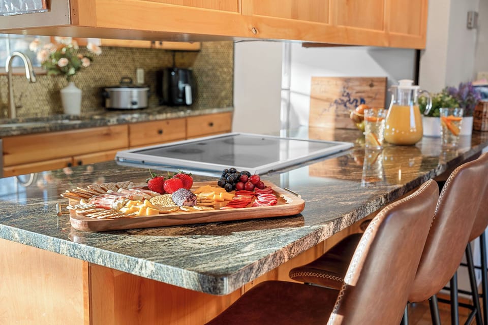 Enjoy gathering in the heart of Whitetail Lodge by Relax and Renew Rentals, where a spacious kitchen island and warm wood finishes create the perfect setting for meals and memories located near Table Rock Lake and the Ozark Mountains in Branson, MO.