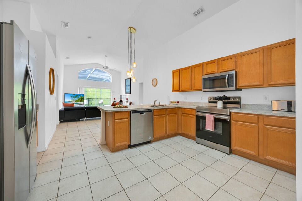 Kitchen | Spacious layout with stainless steel appliances, island counter, and pool view