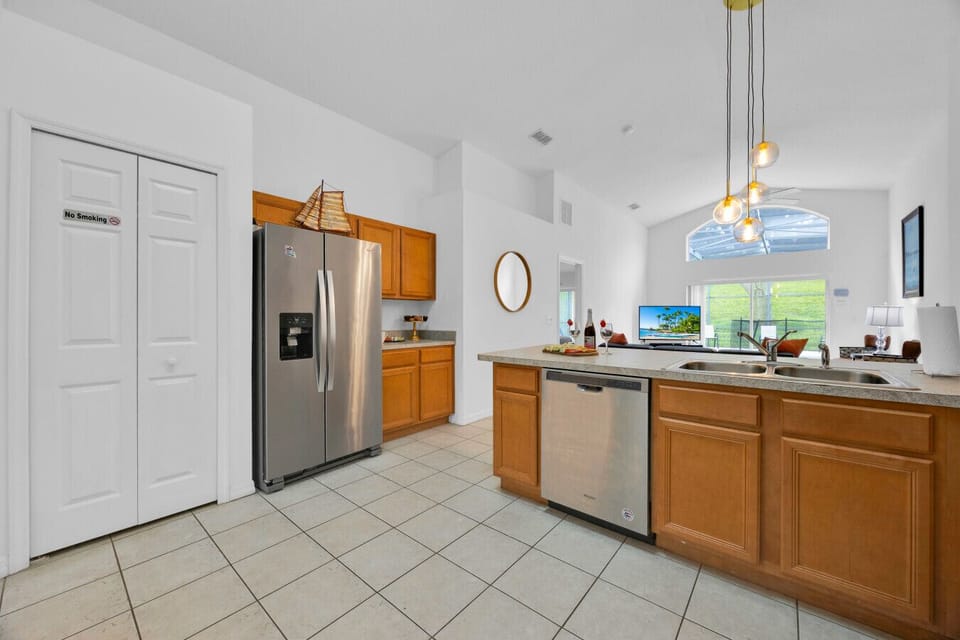 Kitchen | Spacious layout with stainless steel appliances, island counter, and pool view