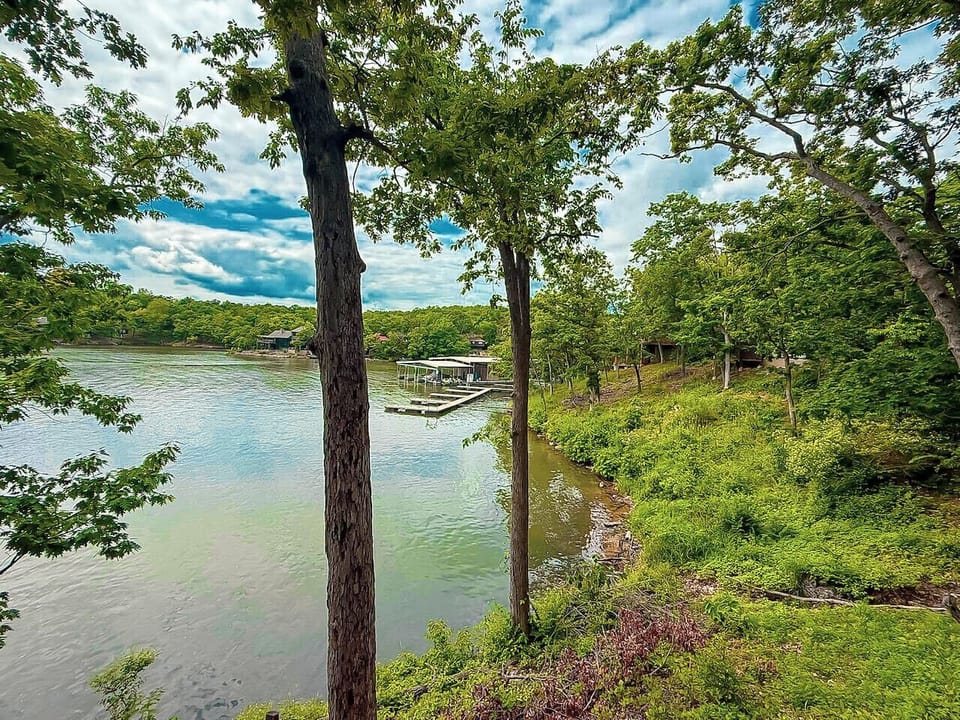 Wake up to peaceful woodland and lake views from the comfort of your cozy bedroom retreat at Branch Bungalow.