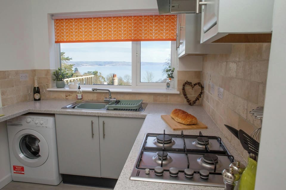 Kitchen with gas hob, washing machine and sea views