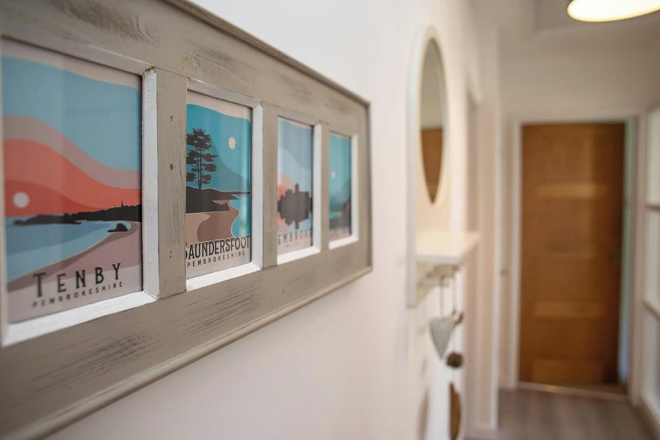 Hallway with local artwork and wall mounted mirror with shelf below