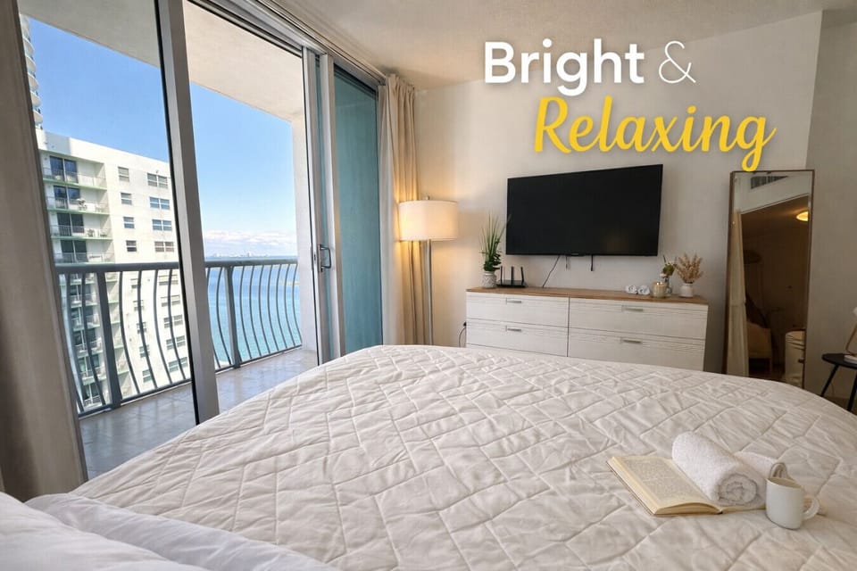 Comfortable bedroom with skyline views and direct access to the private balcony.