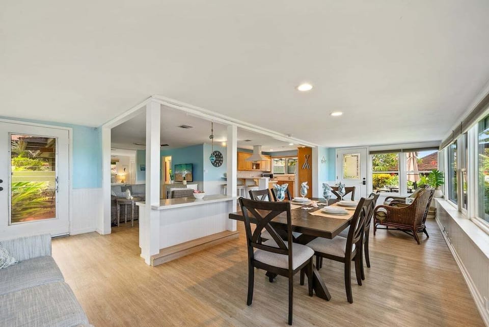 Open-concept dining area with a 6-seater table, large windows, and seamless flow to the kitchen and living room