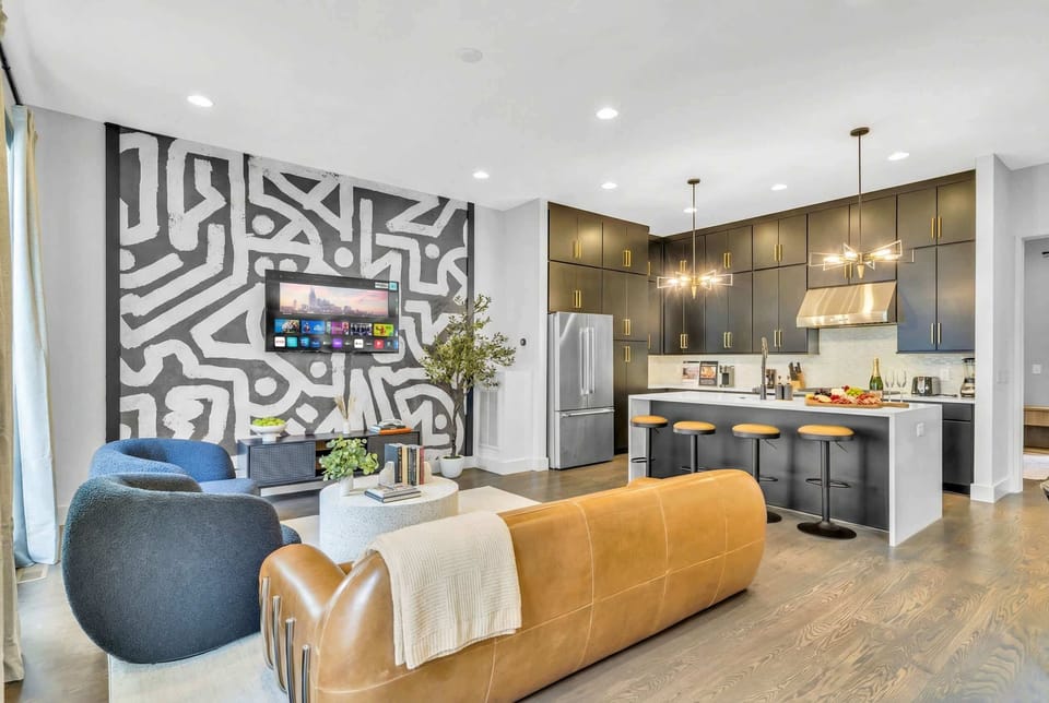 Open-plan kitchen and living room mean the cook stays in the conversation while the group sprawls across sofas and armchairs around a central TV