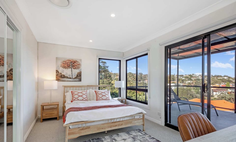 Downstairs Master Bedroom featuring a king bed, balcony access, and water views.