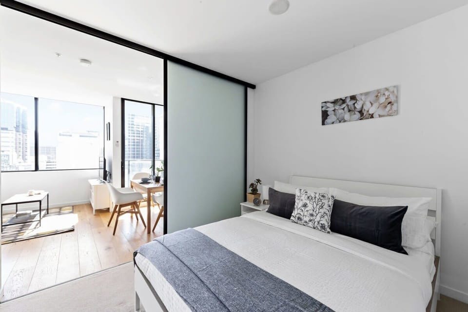 A bedroom with a queen sized bed & plush pillows.