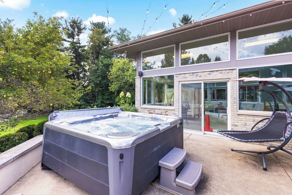 Our outdoor hot tub is located on the third level of the tri-level patio, right outside of the indoor pool house.