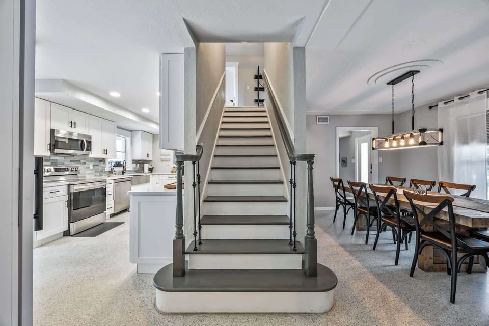 Modern kitchen and dining area with a central staircase connecting the two levels.