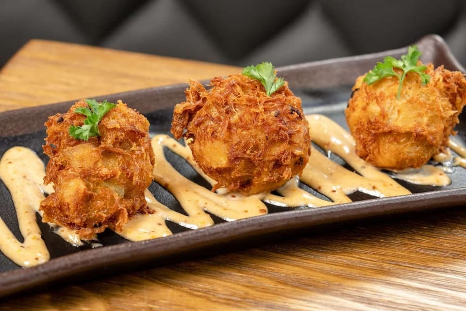 Crispy fried appetizers with dipping sauce on tray