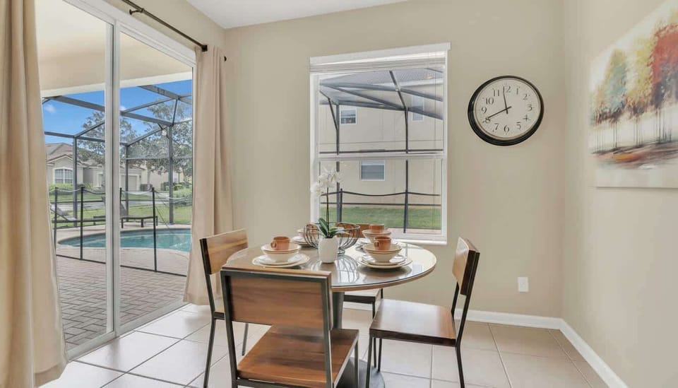 Morning light bathes a modern dining nook overlooking a serene private poolside oasis.