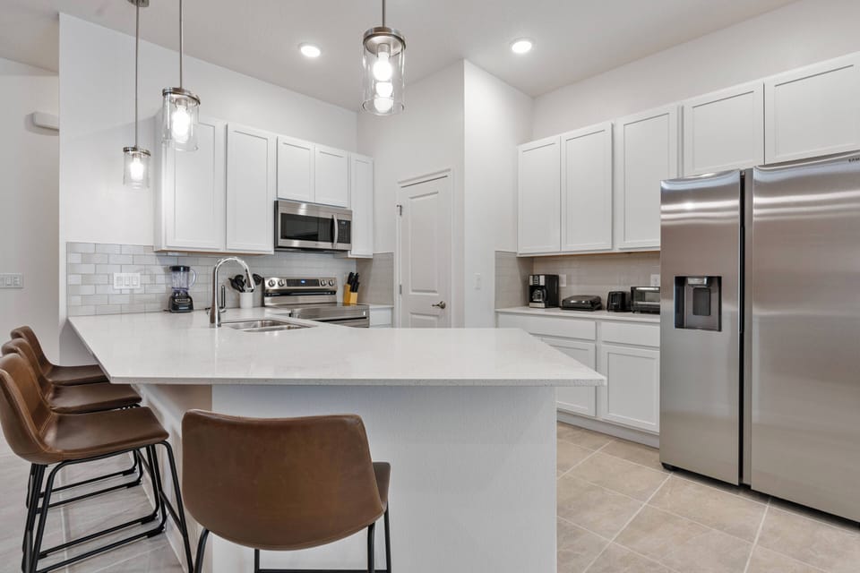 Welcome to this bright kitchen with sleek white cabinetry and stainless-steel appliances, perfect for your culinary adventures.