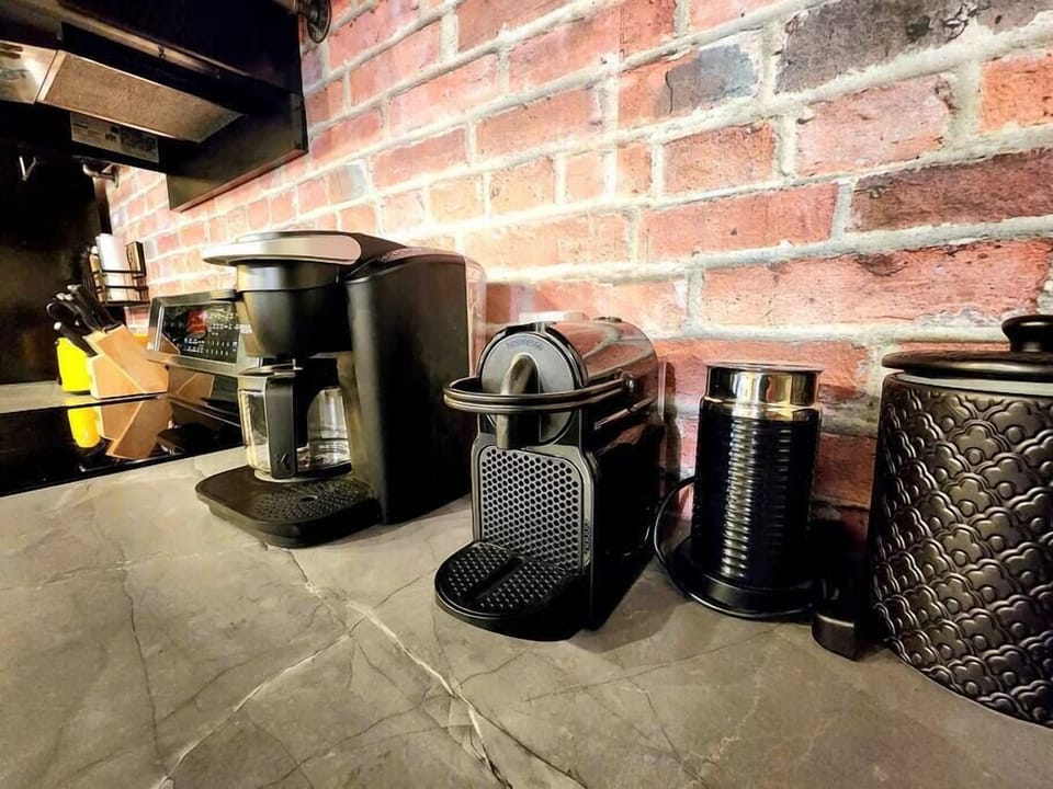 Coin café gourmet : appareils modernes et murs de brique stylés pour un espace idéal où savourer vos créations.