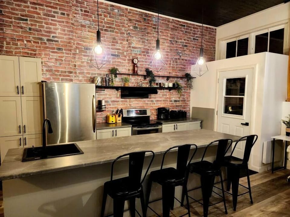 Cuisine style industriel : murs de brique, appareils modernes et design audacieux pour une expérience culinaire vivante.