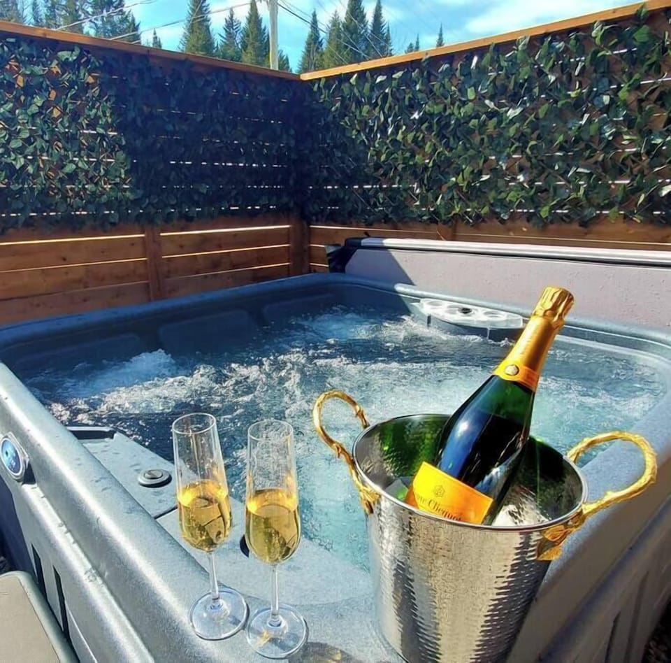 La configuration de détente ultime : un bain à remous chaud, du champagne frais et des flûtes pétillantes, le tout prêt pour votre plaisir.