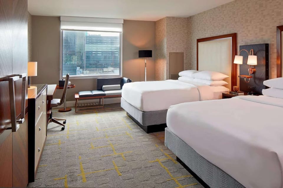 2 Queen beds with lamps and wooden furniture.