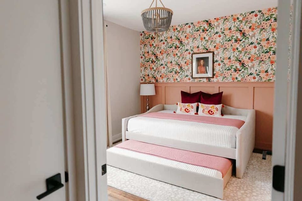 Queen bed with single trundle, custom wallpaper, light filtering blinds, and full en suite bathroom
