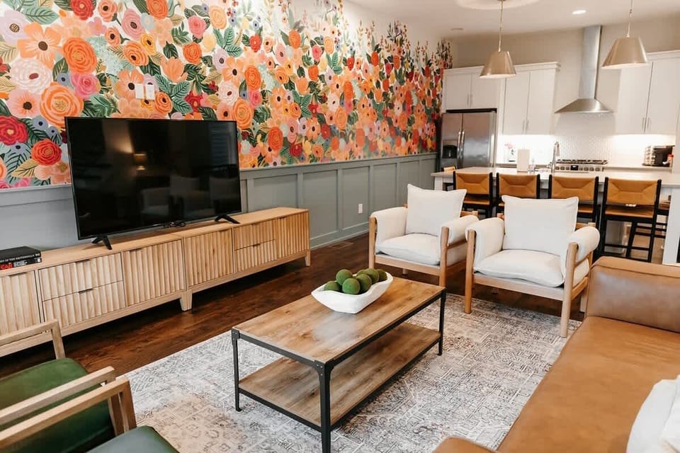 Custom wallpaper, comfy seating, large smart tv for streaming, and plenty of room for large groups