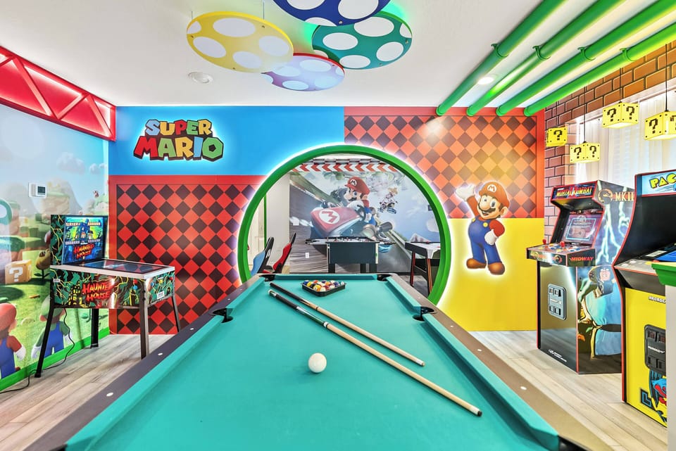 Step into a vibrant game room packed with fun, featuring a stylish pool table and classic arcade machines. With playful Super Mario decor and bright colors, it’s the perfect place for families and friends to unwind together.
