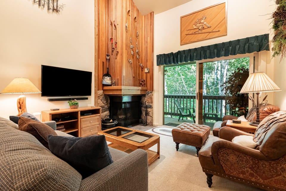 Living Room with Large Flat Screen TV, Gas Fireplace, and Patio Access