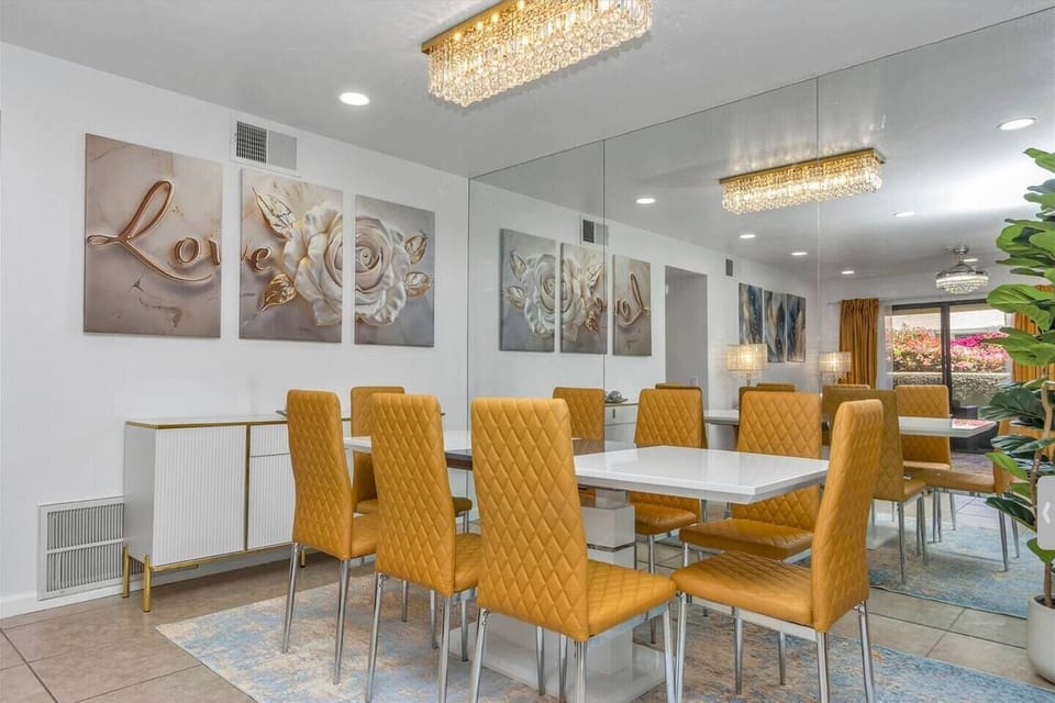 Enjoy meals around a beautiful 8-seat table beneath a stunning chandelier. Surrounded by elegant decor and a vibrant LOVE painting.