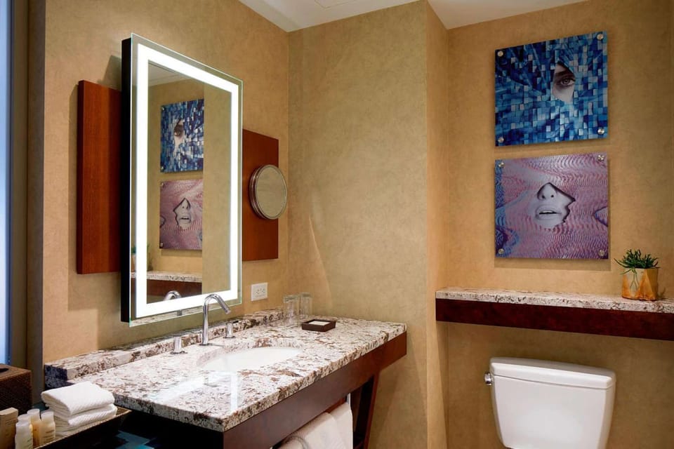 Bathroom with toiletries, shower, and bright lighting.
