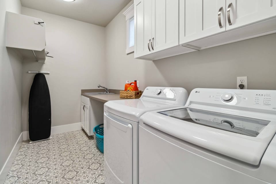 Laundry room with LG washer and dryer, iron, and ironing board