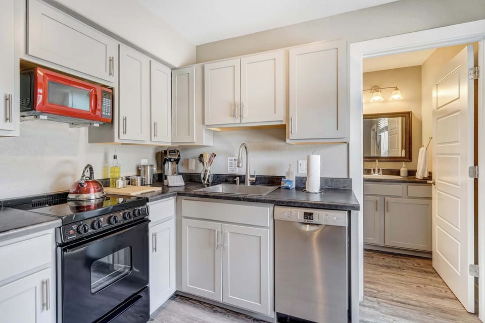 Enjoy the convenience of a well-stocked kitchen with modern appliances, natural light, and easy access to the bathroom just beyond.

