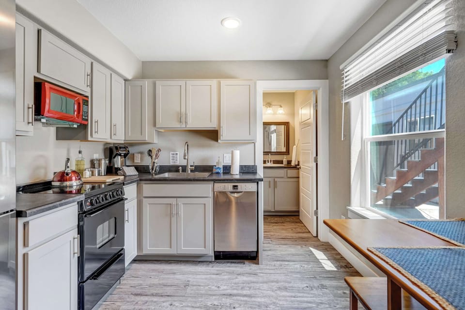Enjoy the convenience of a well-stocked kitchen with modern appliances, natural light, and easy access to the bathroom just beyond.

