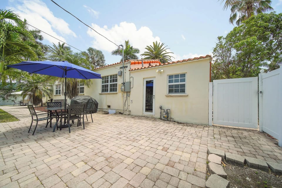 Relax in your private patio oasis with a grill and dining area, surrounded by lush greenery and perfect for outdoor gatherings.
