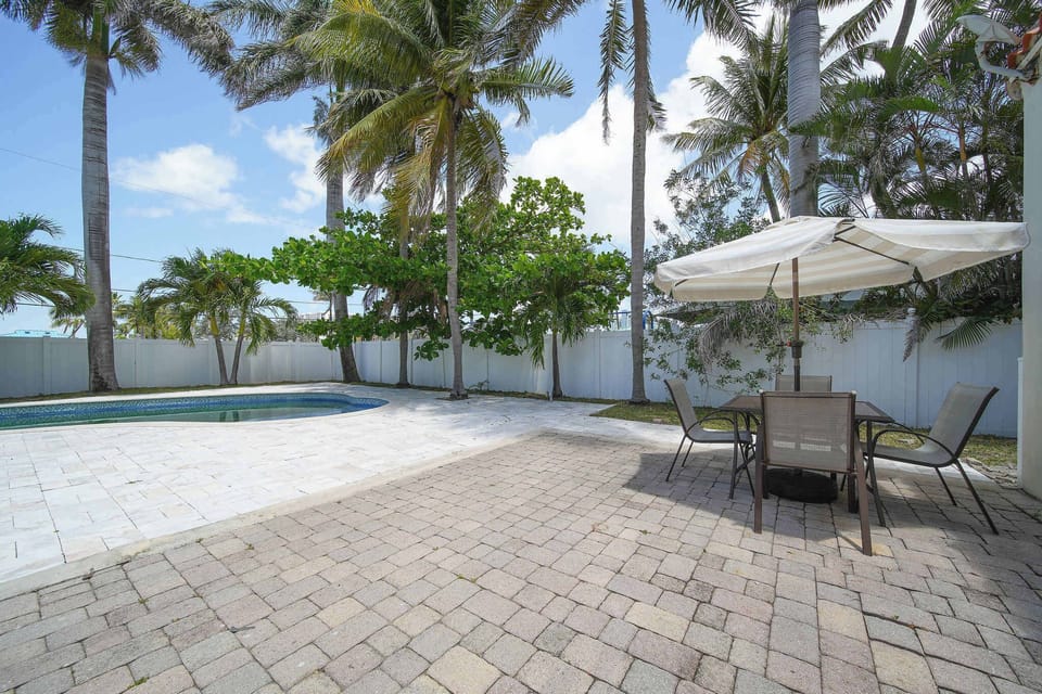 Enjoy a serene retreat by the pool under swaying palms, perfect for sunbathing or dining al fresco.