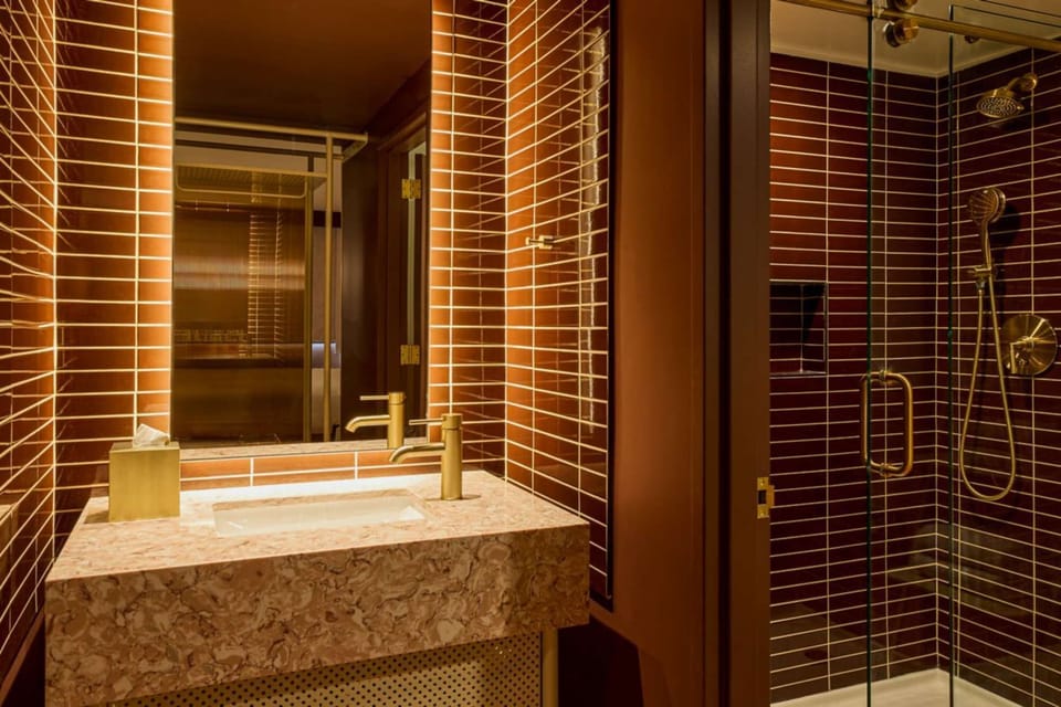 Bathroom with glass shower and brown tile walls