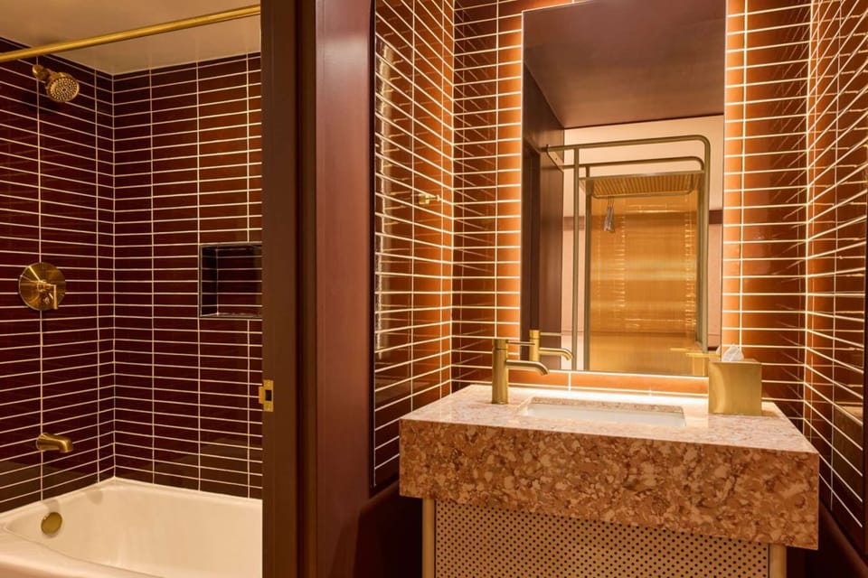 Brown tiled bathroom with tub and sink vanity