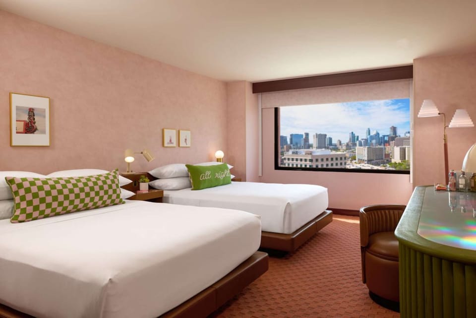 Two queen beds with skyline view and green desk