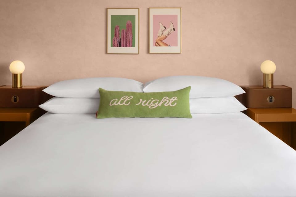 King bed with green pillow and warm bedside lights