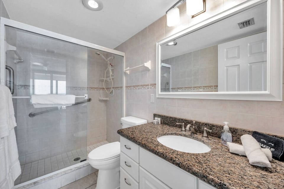 Clean bathroom w/ a spacious vanity, sink, and shower & tub combo.