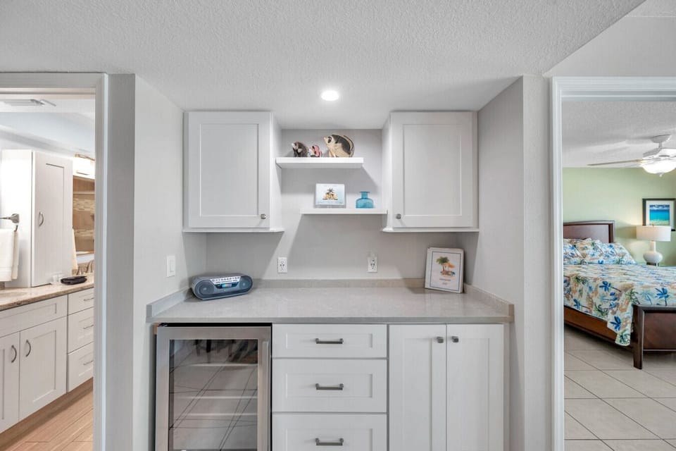 Bright hallway w/ built-in cabinetry and extra storage leading toward the bedrooms