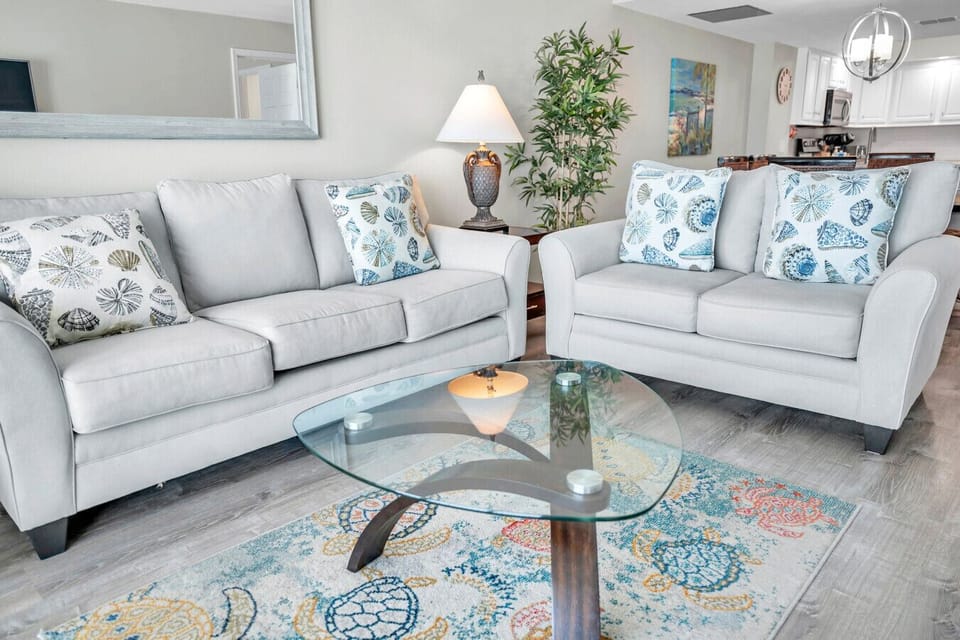 Inviting seating area w/ plush sofa & coastal accents, ideal for lounging or movie nights.