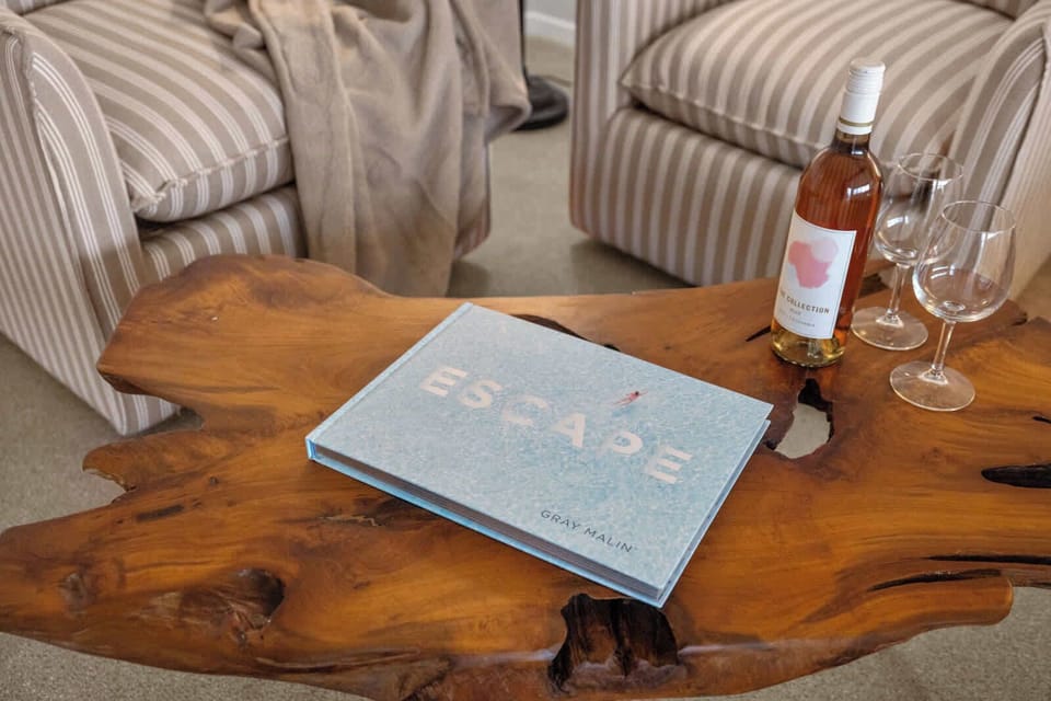 Handmade wood table with local guides and a bottle of rosé – ready for planning your next day on the lake.