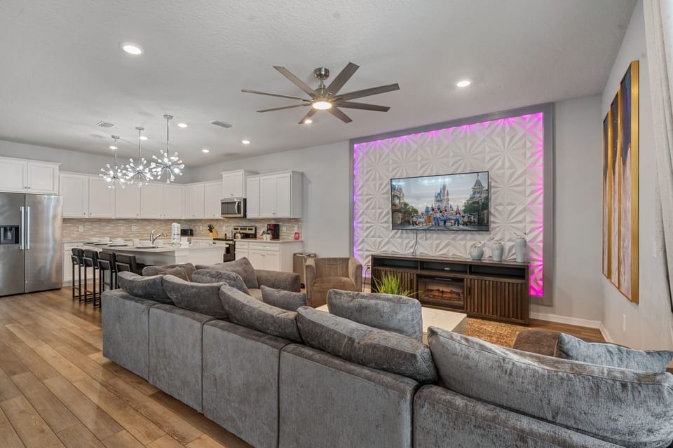 Spacious living area with large sofa, Smart TV and ceiling fan