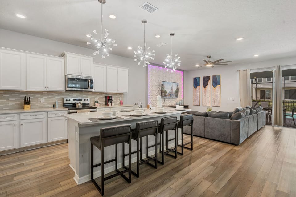 Spacious living area with large sofa, Smart TV and ceiling fan