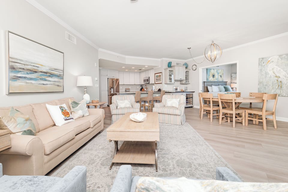 Picture yourself unwinding in this sun-drenched open living space, where soft coastal hues and plush seating invite you to kick back after a day of exploring. Your vacation home blends comfort with beach-inspired elegance.